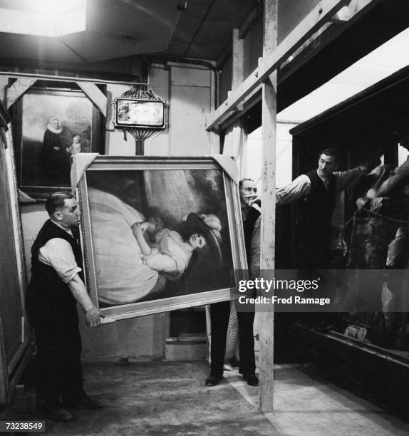 Attendants take 'Portrait of a Lady' by George Romney out of storage for restoration at an underground facility at Manod Quarry, north Wales, where...