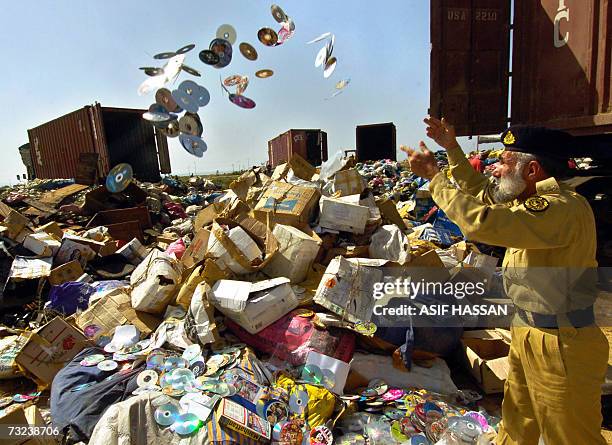 Pakistan customs personal throws pirated CDs amongst other seized contraband items at Neelum Point on the outskirts of Karachi, 07 February 2007....