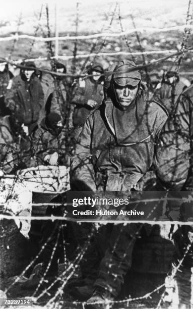 Dejected Argentinian prisoner sits behind barbed wire in a compound on the Falklands Islands during the war with British forces, June 1982. Over 1200...