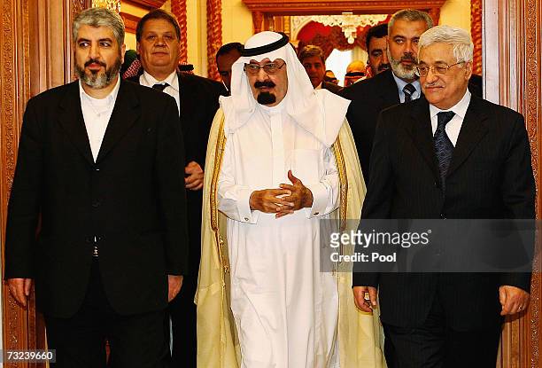 Saudi Arabia's King Abdullah walks out with Palestinian President Mahmoud Abbas and Hamas leader Khaled Meshaal after their meeting February 7, 2007...