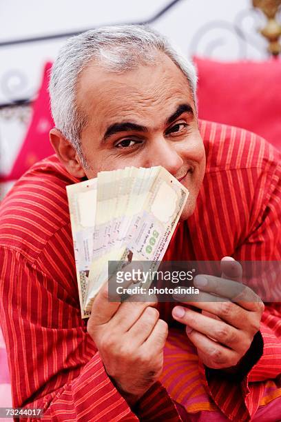 portrait of a mid adult man showing indian currency notes - indian rupee note stock pictures, royalty-free photos & images
