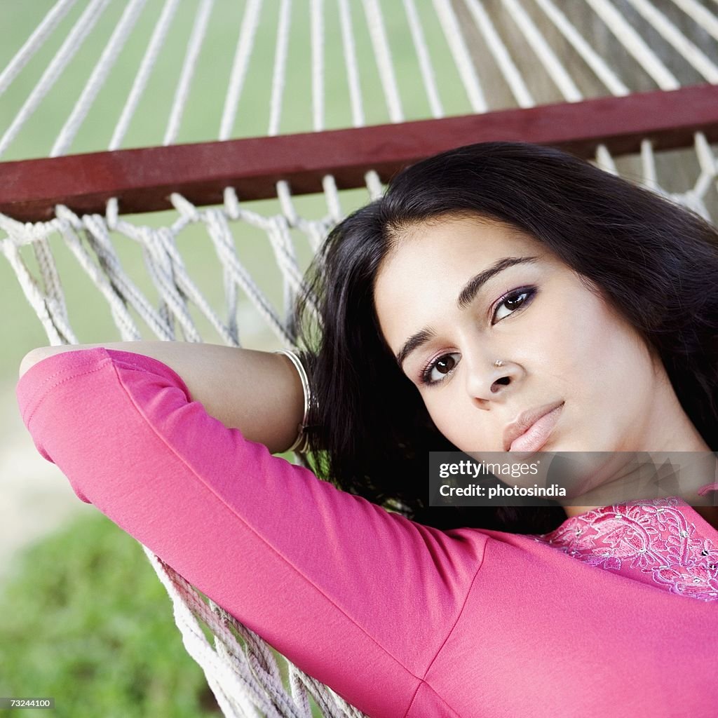 Portrait of a young woman lying in a hammock