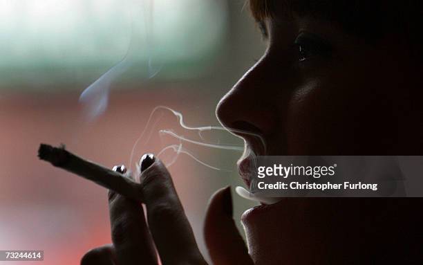 Woman smokes a cigarette of marijuana in an Amsterdam cafe on February 7, 2007 in Amsterdam, Netherlands. The city council in Amsterdam has recently...