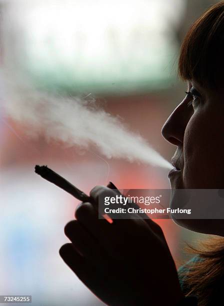 Woman smokes a cigarette of marijuana in an Amsterdam cafe on February 7, 2007 in Amsterdam, Netherlands. The city council in Amsterdam has recently...