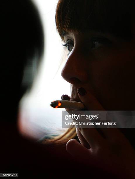 Woman smokes a cigarette of marijuana in an Amsterdam cafe on February 7, 2007 in Amsterdam, Netherlands. The city council in Amsterdam has recently...