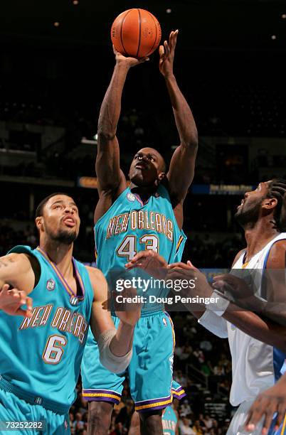 Linton Johnson of the New Orleans/Oklahoma City Hornets takes a shot over teammate Tyson Chandler and Nene of the Denver Nuggets during NBA action on...