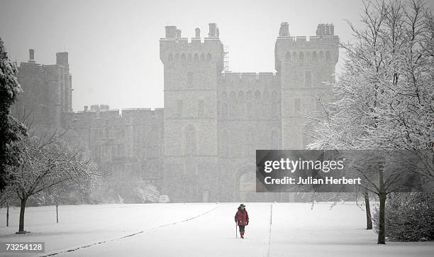 Walker battles through the snow in front of Windsor Castle on February 8 in Windsor, England. Travel chaos grips Southern England as heavy snow fell...