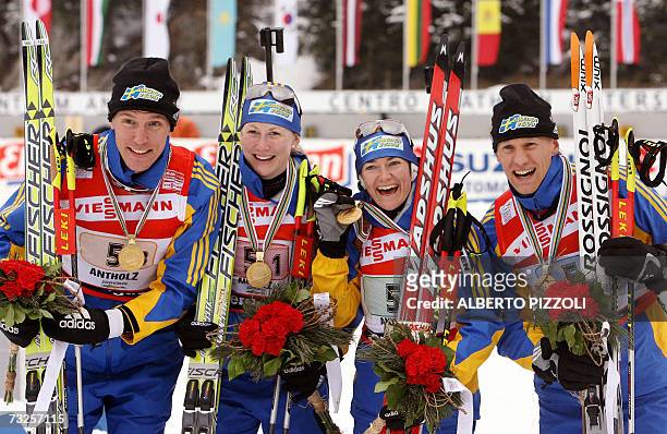 Sweden team Bjorn Ferry, Helena Jonsson, Anna Carin Olofsson and Carl Johan Bergman pose with their gold medals as they won the mixed 2 x 6 + 2 x 7.5...