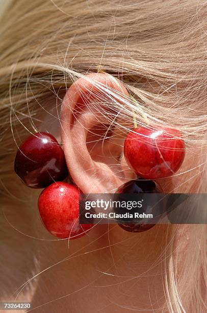 girl wearing cherries on ear, close-up - människoöra bildbanksfoton och bilder