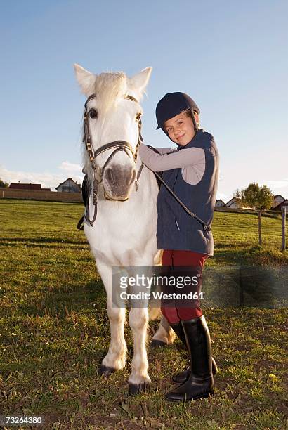 girl (10-12) standing by pony, portrait - riding hat fotografías e imágenes de stock