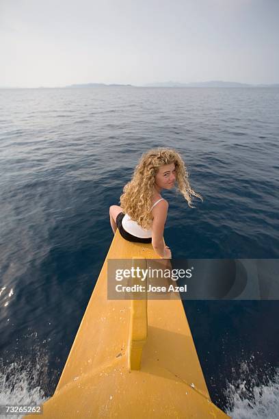 a teenage girl enjoys the sea breeze as she sits on the prow of a boat cruising the adriatic sea near kornati national park. - croatia girls stock-fotos und bilder