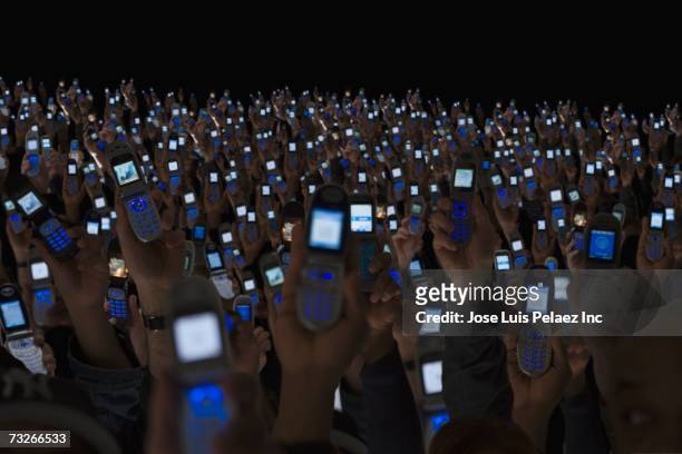 large group of people holding open cell phones up in air - holding aloft stock-fotos und bilder