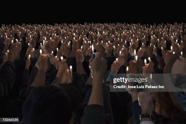 rear view of people holding lit lighters up in air - cigarette lighter 個照片及圖片檔