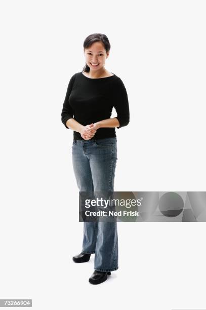studio shot of native american woman smiling with hands clasped - full body portrait asian american woman white background stock-fotos und bilder