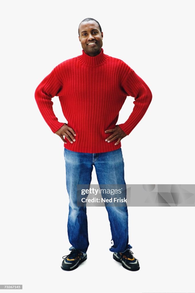 Studio shot of African man smiling with hands on hips