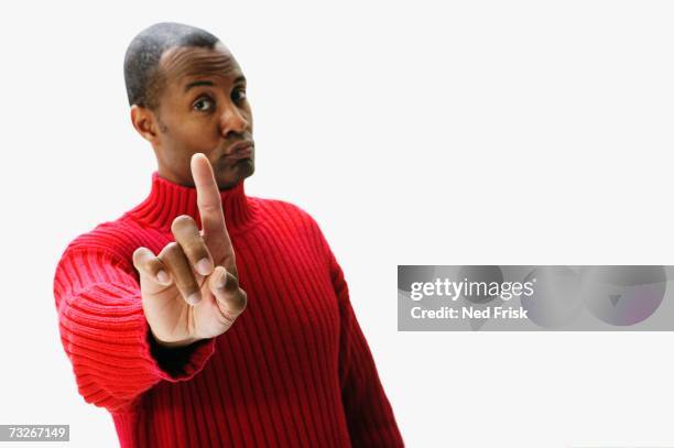 studio shot of african man with index finger up and lips pursed - hand opsteken stockfoto's en -beelden