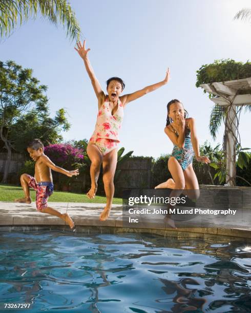 grandmother and grandchildren jumping into swimming pool - hot filipina women stockfoto's en -beelden