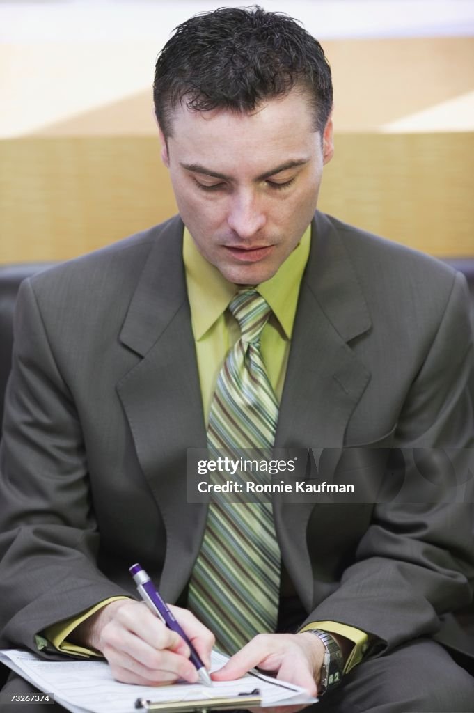 Close up of businessman filling out paperwork