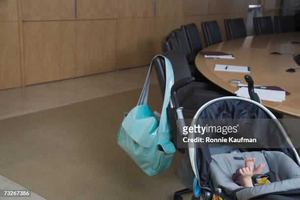 baby in stroller and diaper bag over back of chair at conference table - diaper bag 個照片及圖片檔