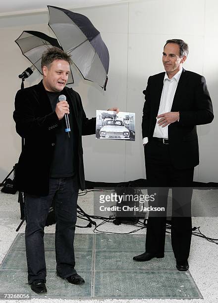 Photographer Rankin holds up a picture of himself as a young boy sitting on a Ford next to Roelant de Waard at the private viewing of ''Ford Motor...
