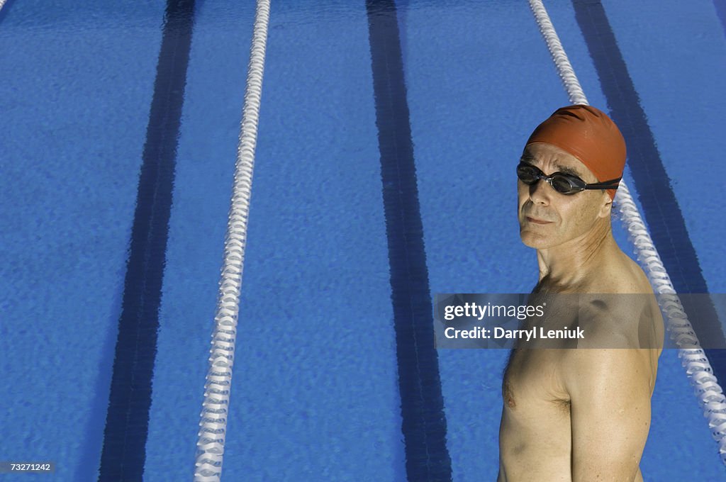 Competitive swimmer standing by pool