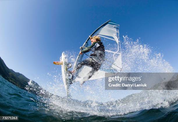 man jumping wave on windsurf board, low angle view - vindsurfing bildbanksfoton och bilder