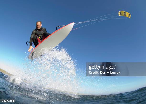 man kiteboarding, low angle view - kiteboarding fotografías e imágenes de stock