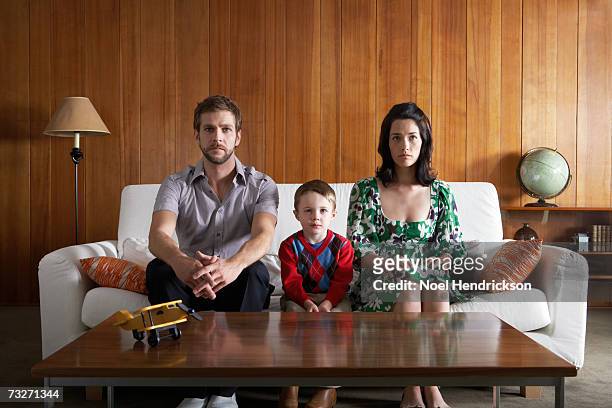 parents and son (3-5) sitting on couch, in living room - sofa stock pictures, royalty-free photos & images