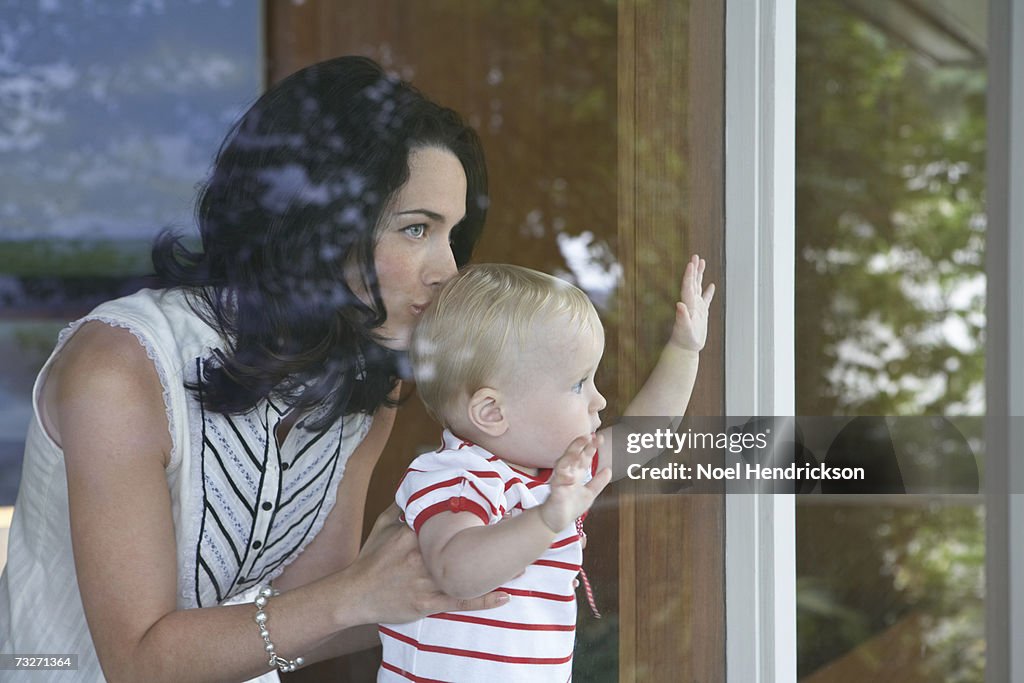 Mutter holding baby Mädchen (9-12 Monate), Fenster