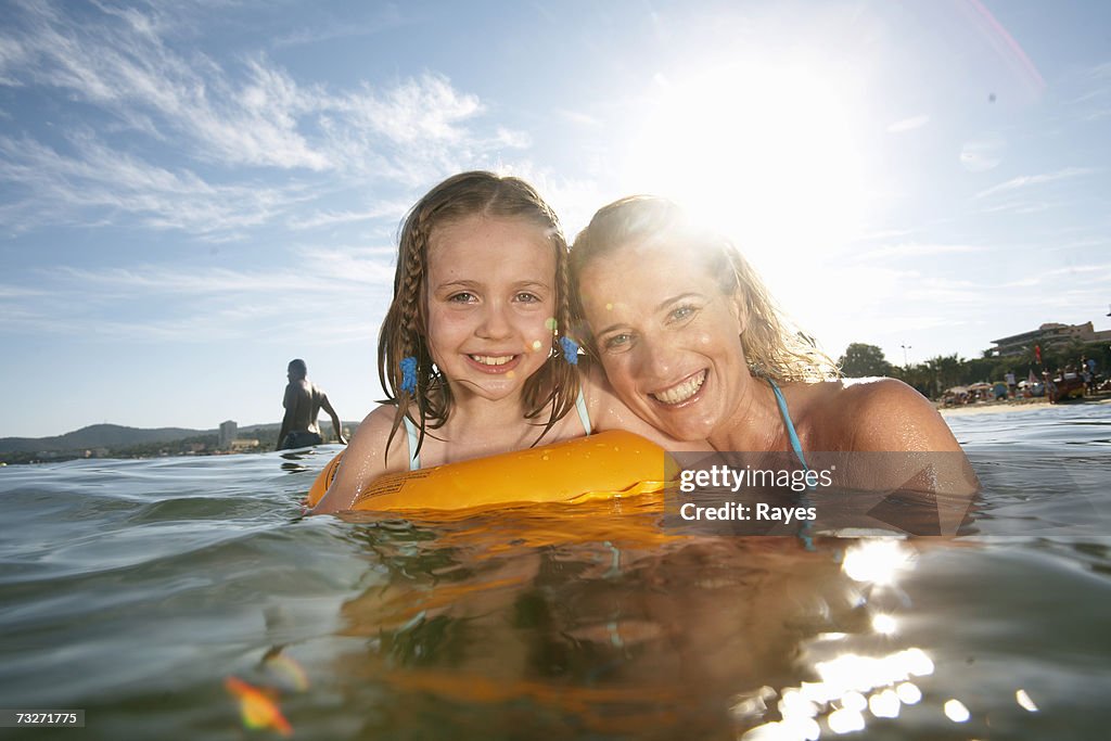 Mother swimming with daughter (7-9) in sea