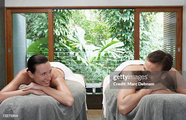couple lying on massage tables at health spa - massage couple stock pictures, royalty-free photos & images