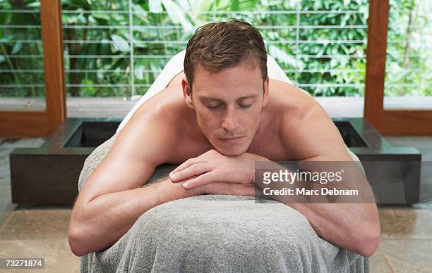 man lying on massage table at health spa - マッサージ台 ストックフォトと画像