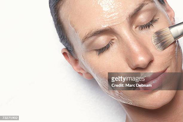 young woman having facial treatment, close-up - mud mask photos et images de collection