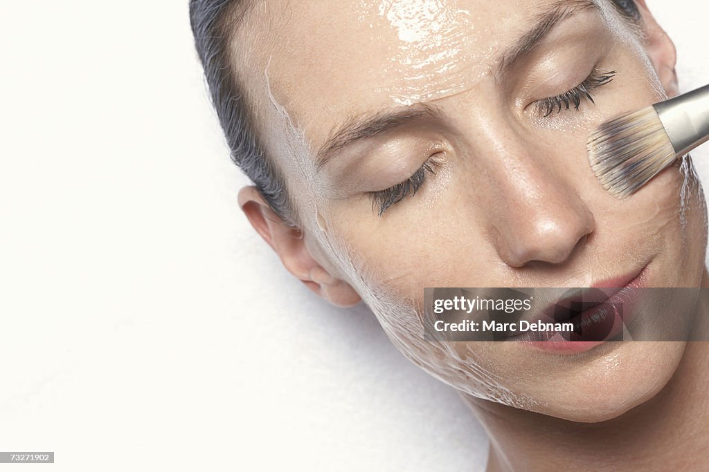Young woman having facial treatment, close-up