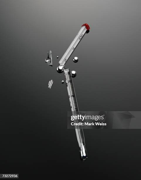 broken thermometer with mercury spilling out - mercurio fotografías e imágenes de stock