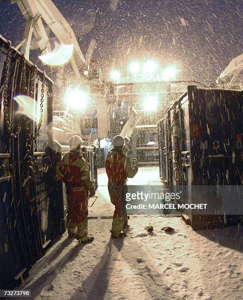 Deux marins du remorqueur de haute-mer norvegien "Bourbon Surf" travaillent au dechargement de materiel offhore au pied d'une plateforme petroliere...