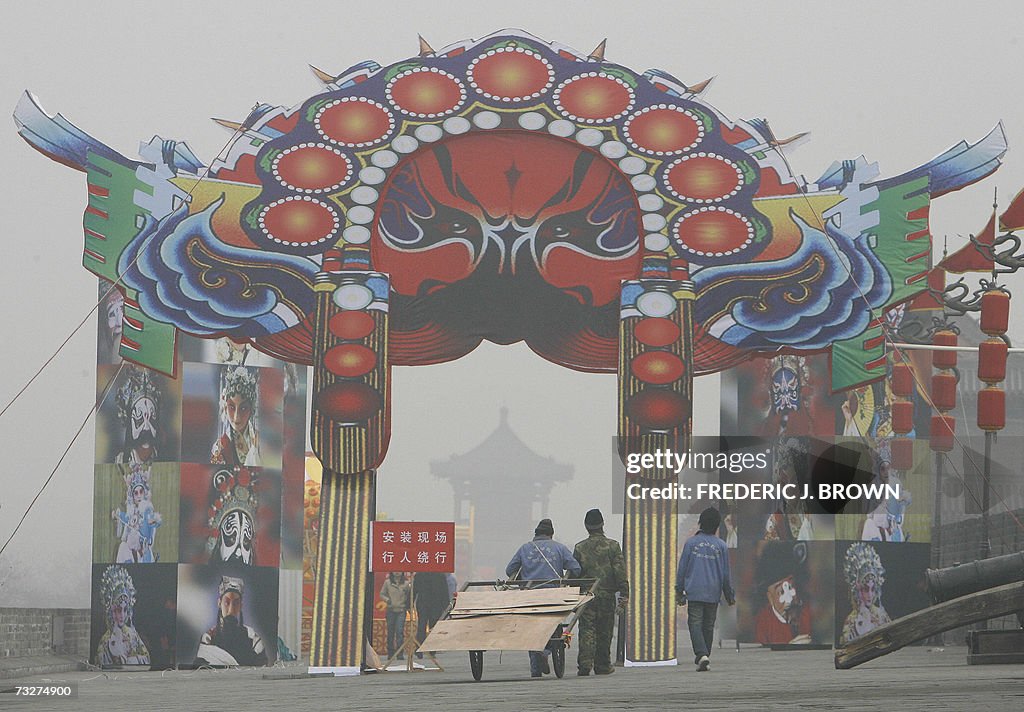 Workers walk through an archway on a pol...