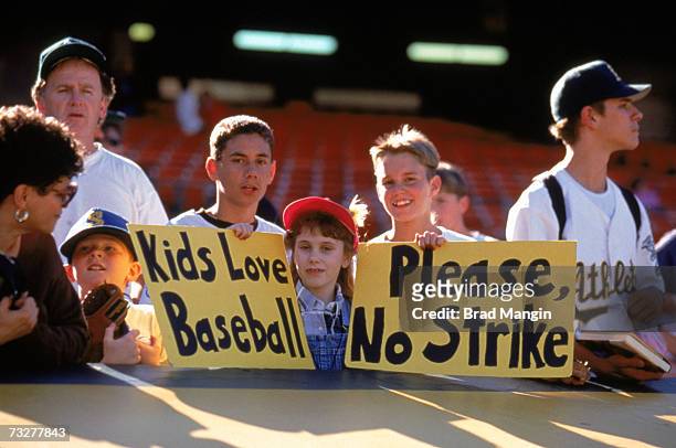 Fans hold up signs in protest of the baseball strike prior to the game between the Seattle Mariners and the Oakland Athletics at the Oakland Coliseum...