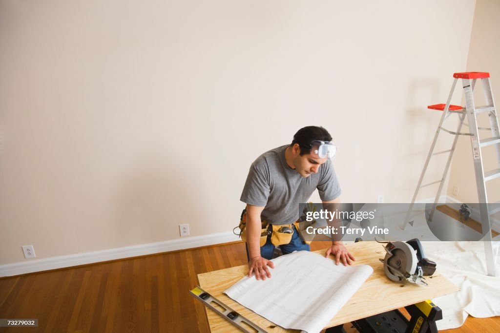 Man looking at blueprints for home improvement