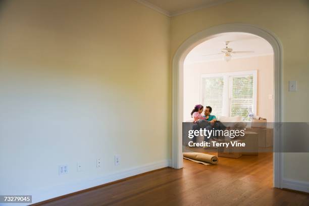couple hugging on sofa next to moving boxes - embracing change stock pictures, royalty-free photos & images