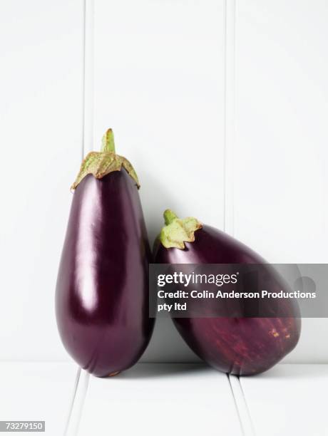 close up of eggplants leaning against wall - aubergine stock pictures, royalty-free photos & images