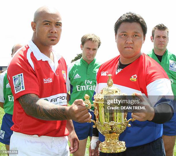 Auckland, NEW ZEALAND: Tongan captain 'Otenili Latu and Korean captain Tae-Hyung Kim hold the William Webb Ellis Rugby World Cup prior to the IRB...