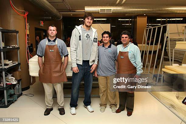 Andrew Bogut of the Milwaukee Bucks poses with store employees after the final construction on his custom-made 7.5 foot by 8 foot mattress on...