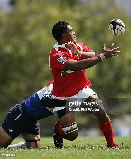 Isileli Fine of Tonga passes the ball as he is tackled by Tae-Hyung Kim of Korea during the Rugby World Cup 2007 Qualifier match between Korea and...