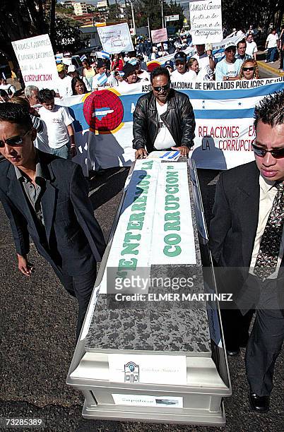 Tegucigalpa, HONDURAS: Hombres vestidos de negro sostienen un ataud con la leyenda ''Enterremos la Corrupcion'' durante la "Marcha por la Integridad...