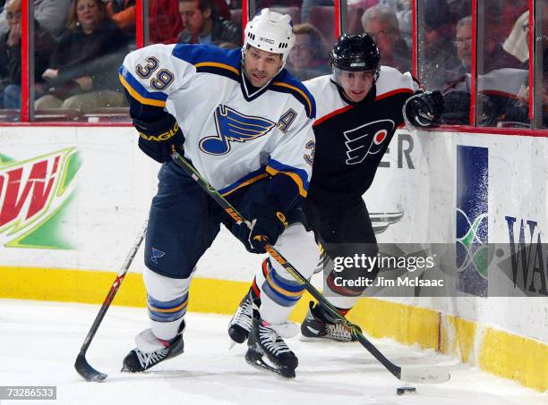 Doug Weight of the St. Louis Blues keeps the puck from Denis Gauthier of the Philadelphia Flyers during their game on February 10, 2007 at the...