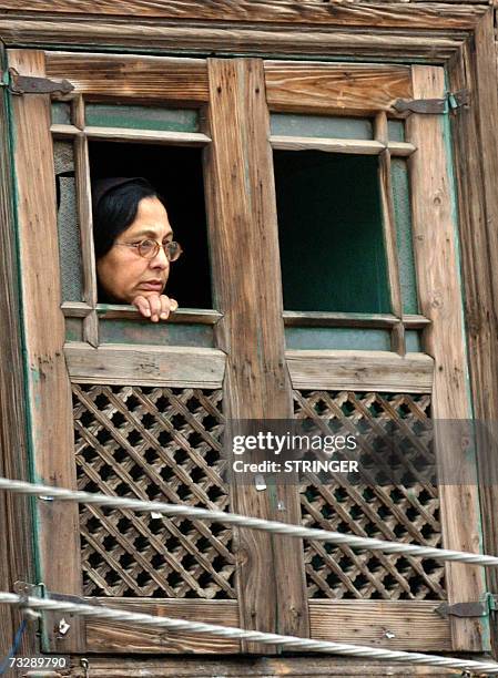 Kashmiri Muslim woman watches from the window of her house a clash between protestors and police in downtown Srinagar, 11 February, 2007. Violent...