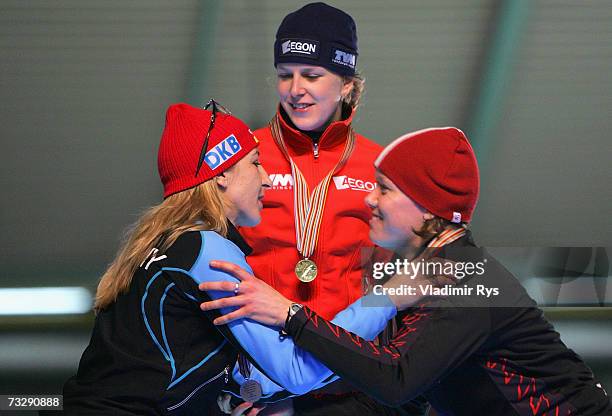 Anni Friesinger of Germany kisses Cindy Klassen of Canada , as Ireen Wust of Netherlands looks on during the medal ceremony of the World Allround...