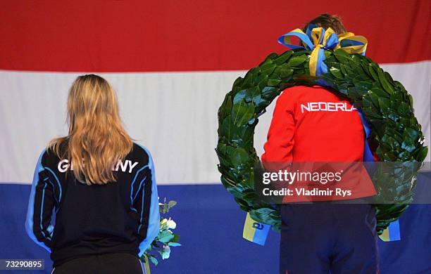 Anni Friesinger of Germany and Ireen Wust of Netherlands stand up for the national anthem of Netherlands during the medal ceremony of the World...