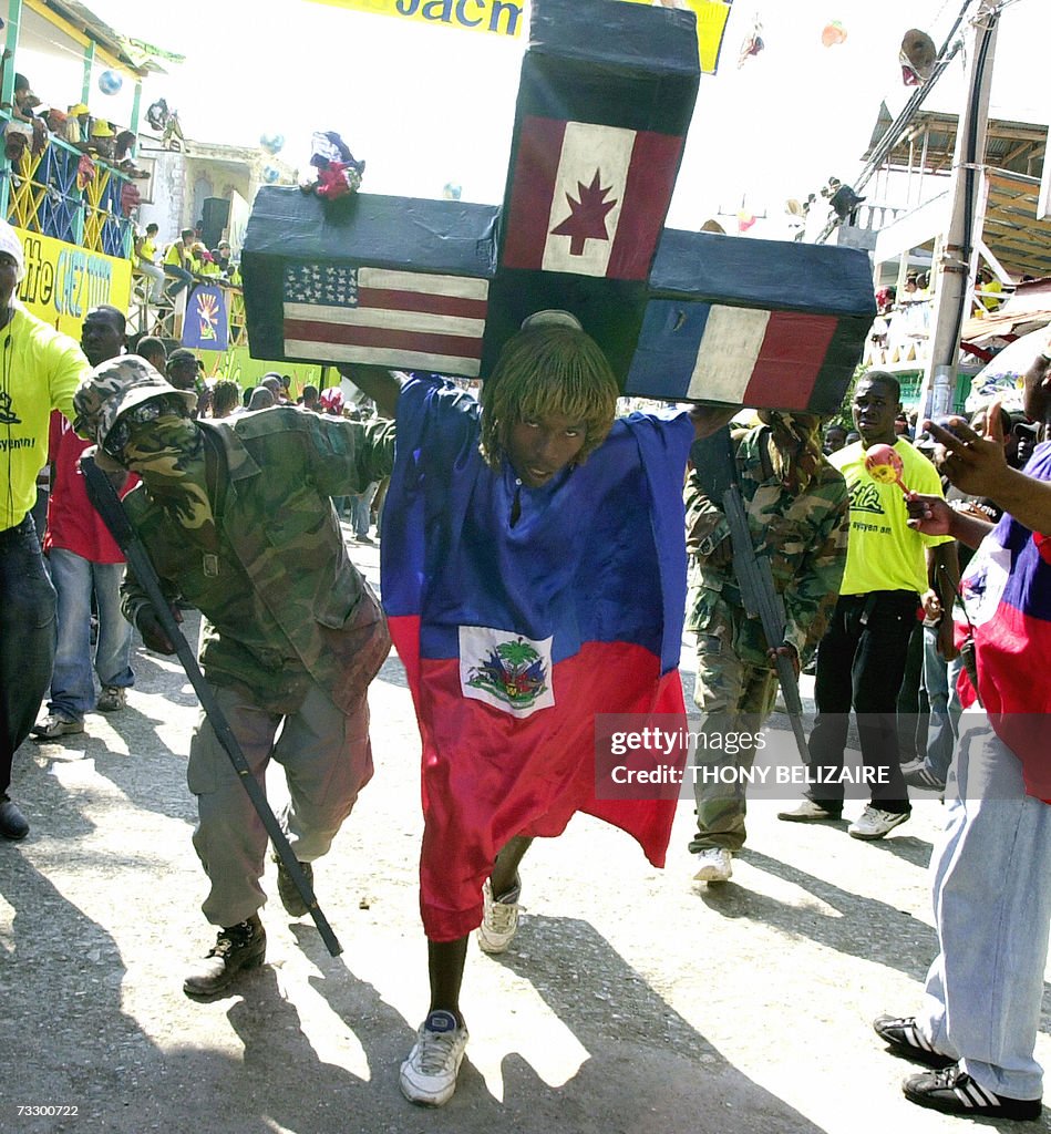 A man wearing the Haitian flag carries a...
